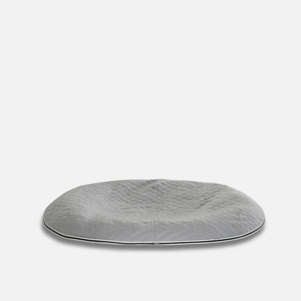 En stor, rund, grå quiltet gulvpude med en let indrykket midte, designet som en vannavvisende hundeseng med ThermoQuilt-materiale, placeret på en almindelig hvid baggrund.