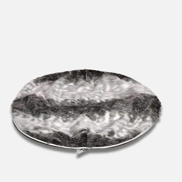 En rund, flad hundeseng med en luksuriøs pelstopp og blød fuskepelstrekk i grå, hvide og sorte toner. En synlig lynlås løber langs kanten, vist på en almindelig hvid baggrund.