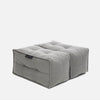 En firkantet, grå, tuftet gulvpude eller designerpuf med synlige sømlinjer og blød stofstruktur på en almindelig hvid baggrund - perfekt til ethvert Ambient Lounge-miljø.