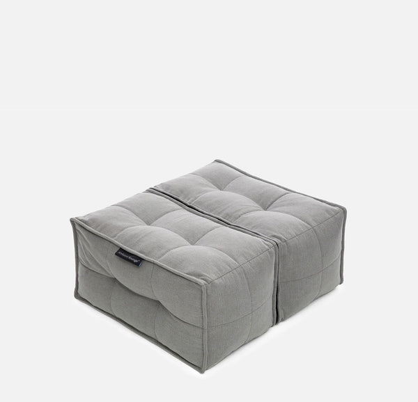 En grå, firkantet, tuftet gulvpude med en søm i midten, der ligner to forbundne sædepuder - denne Ambient Lounge Twin Ottoman bringer alsidig designer-ottoman-stil til ethvert rum.